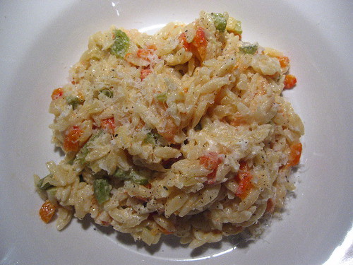 Rice-shaped pasta with bell peppers and fresh goat's cheese